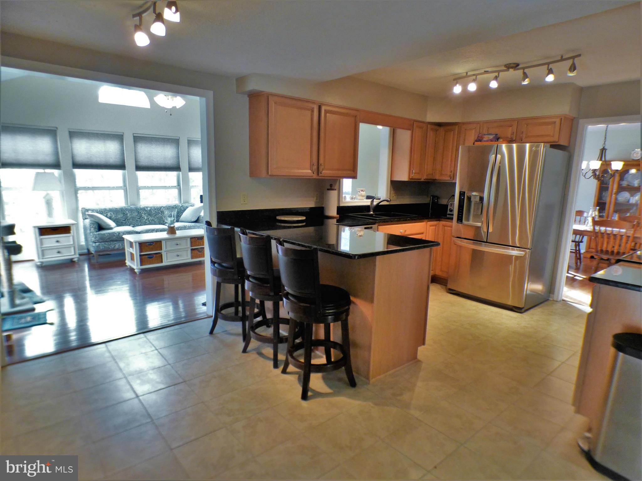 1521 Stinnett Road Huntingtown, MD 20639 - Photo 6 of 30 a kitchen with stainless steel appliances a table and chairs in it