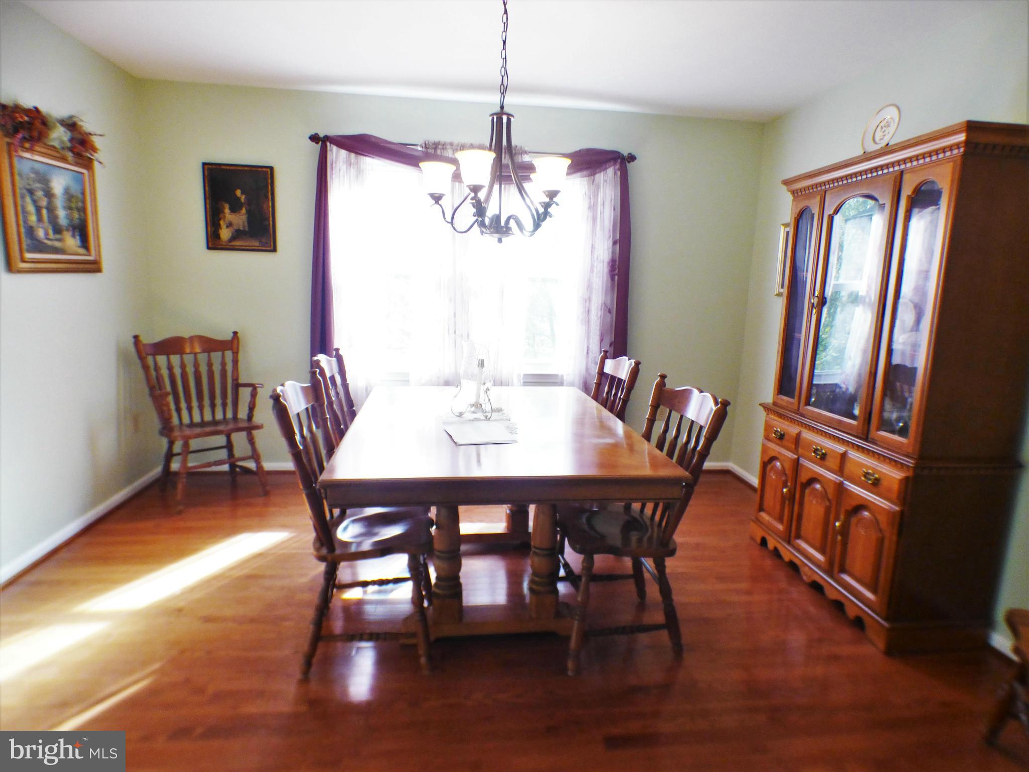 1521 Stinnett Road Huntingtown, MD 20639 - Photo 7 of 30 a view of a dining room with furniture window and wooden floor