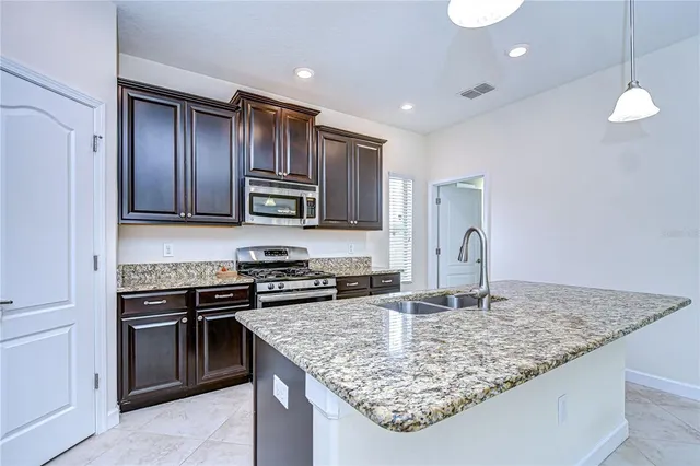a kitchen with stainless steel appliances granite countertop a sink stove and refrigerator