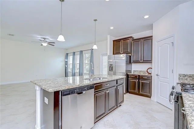 a view of an empty room with a chandelier fan