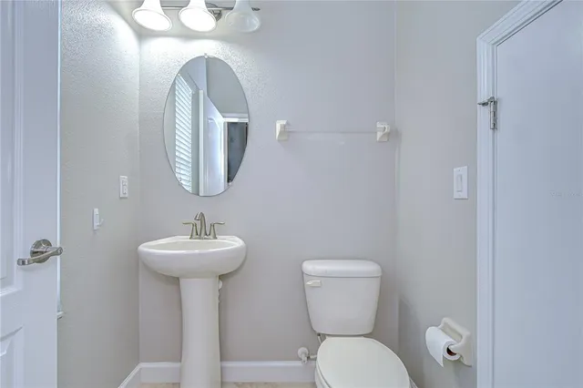 a front view of a house with a yard and potted plants