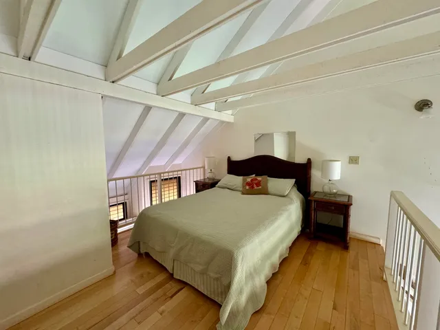 a bedroom with a bed and a wooden floor