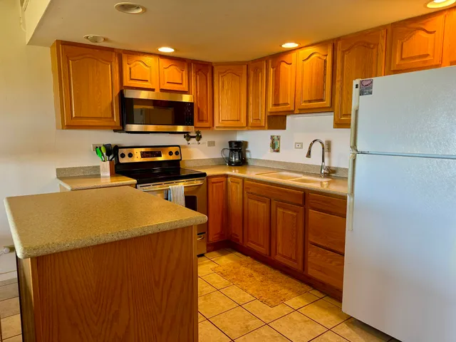 a kitchen with stainless steel appliances granite countertop a refrigerator sink stove microwave and cabinets