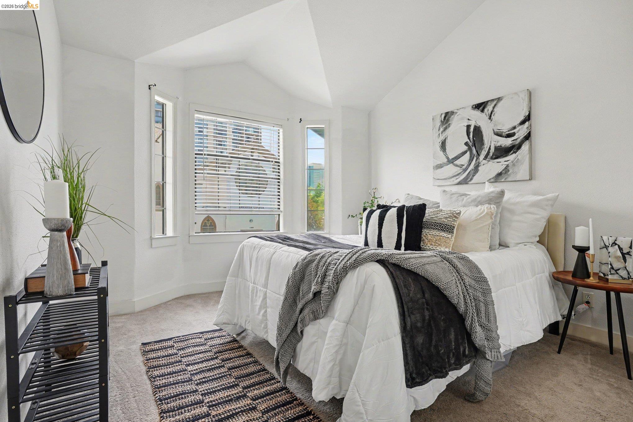 1433 Myrtle Street Oakland, CA 94607 - Photo 14 of 25 Vaulted ceiling bedroom featuring plush carpet flooring, a bay window with blinds, and white painted walls