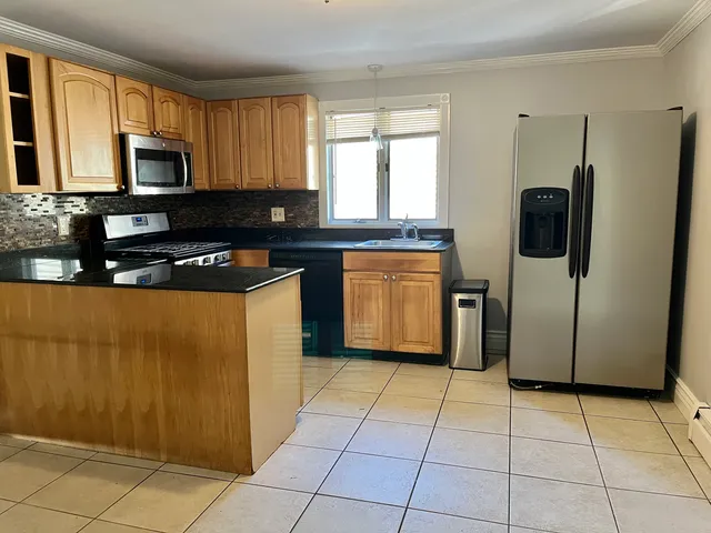 a kitchen with stainless steel appliances granite countertop a refrigerator and a stove top oven