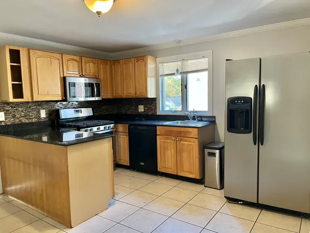 a kitchen with stainless steel appliances granite countertop a stove a sink and a refrigerator