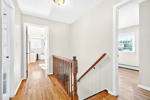 a view of a hallway with wooden floor and staircase