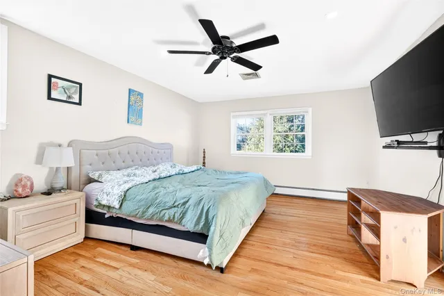 a spacious bedroom with a bed and a flat screen tv