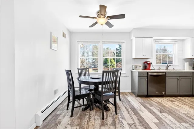 a kitchen with a table chairs a sink dishwasher window and cabinets