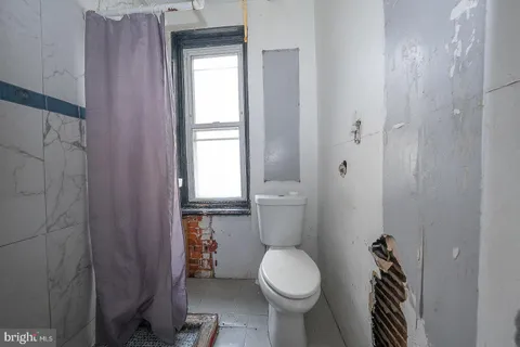 a bathroom with a toilet a sink and shower