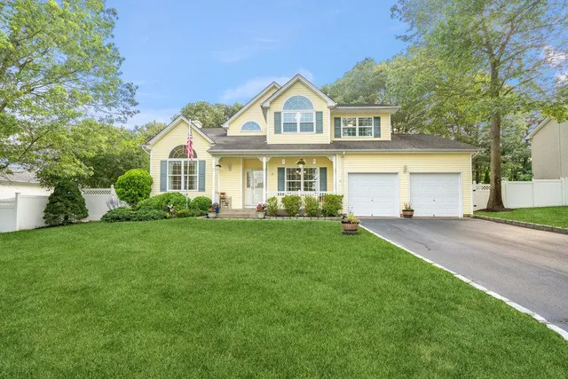 a front view of a house with a garden and trees