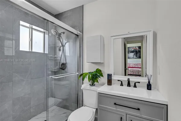 a bathroom with a sink mirror and toilet