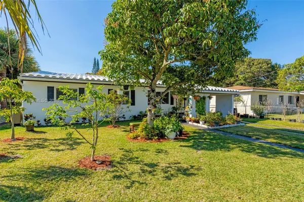 a view of a house with backyard and sitting area