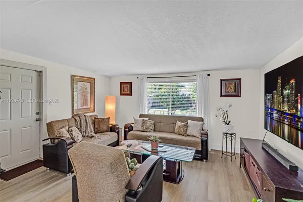 a living room with furniture a bookshelf and a window