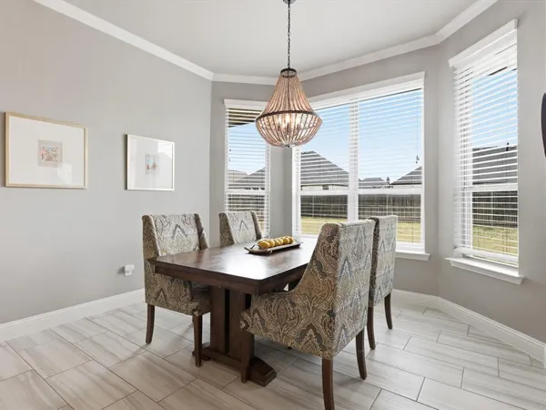 a dining room with furniture a chandelier and window