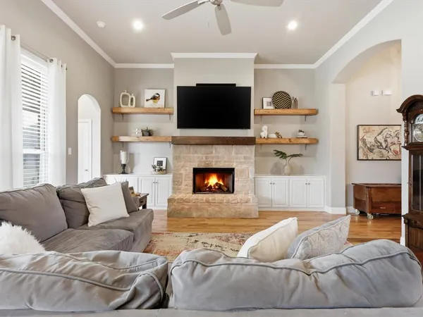 a living room with furniture a flat screen tv and a fireplace