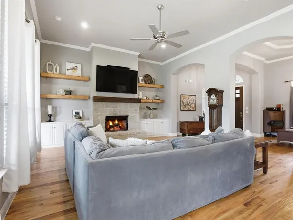 a living room with furniture a flat screen tv and a fireplace