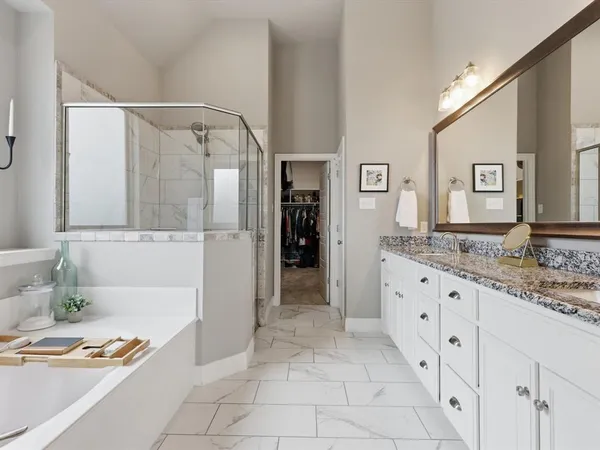 a bathroom with a granite countertop sink a mirror and a bathtub