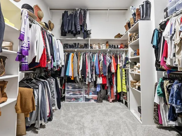 a view of walk in closet with clothes