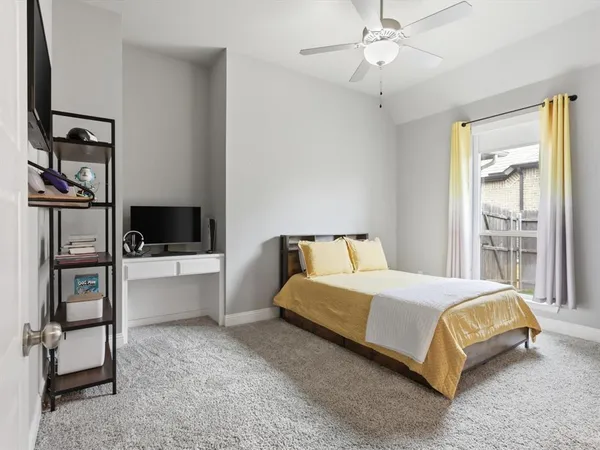 a bedroom with a bed and a flat tv screen on dresser
