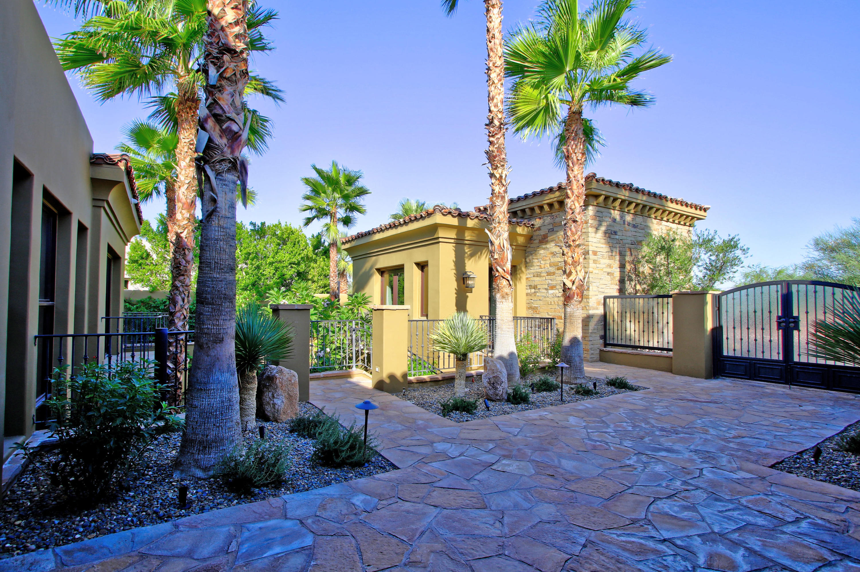 83 Royal St Georges Way Rancho Mirage, CA 92270 - Photo 11 of 123 a front view of a house with a yard and potted plants