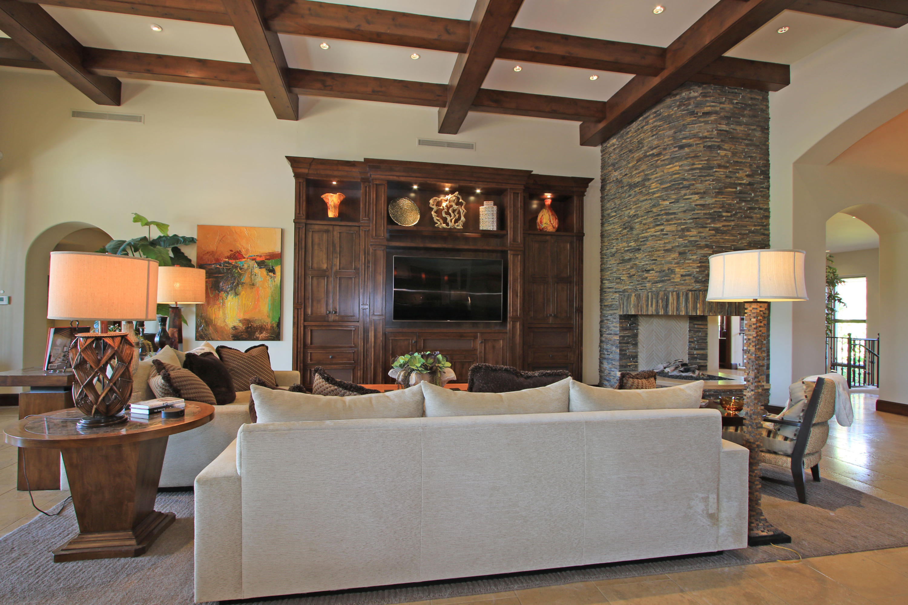83 Royal St Georges Way Rancho Mirage, CA 92270 - Photo 23 of 123 a living room with couches a fireplace and a dining table with a large window