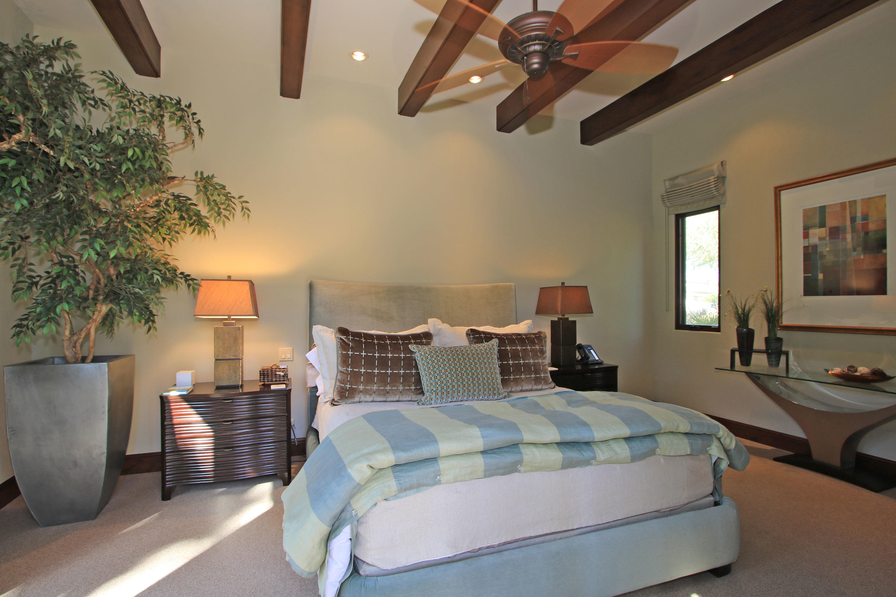 83 Royal St Georges Way Rancho Mirage, CA 92270 - Photo 96 of 123 a bedroom with a large bed and a chandelier
