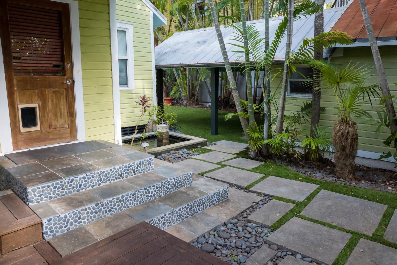 1120 Seminary Street Key West, FL 33040 - Photo 24 of 42 a view of a brick house with a yard potted plants and a table and chair