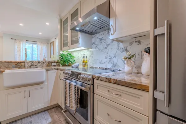 a kitchen with stainless steel appliances granite countertop a sink and cabinets
