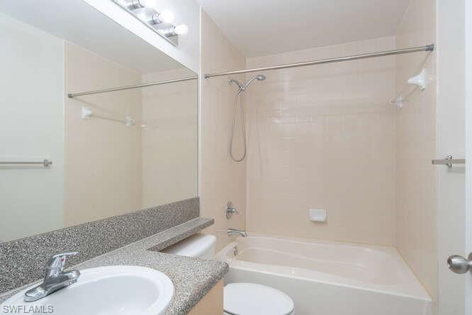1220 Reserve Way, Unit 305 Naples, FL 34105 - Photo 13 of 20 a bathroom with a granite countertop bathtub shower sink and toilet
