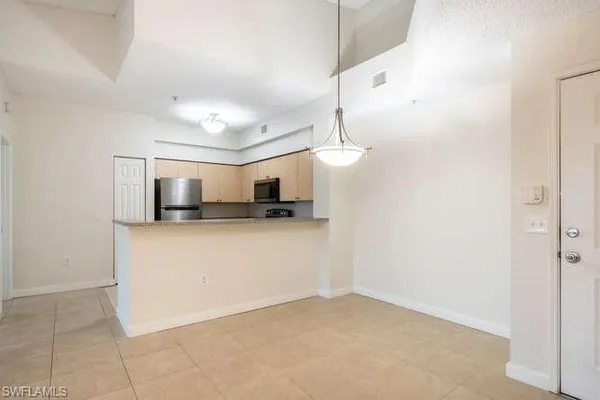 a view of kitchen with microwave and refrigerator
