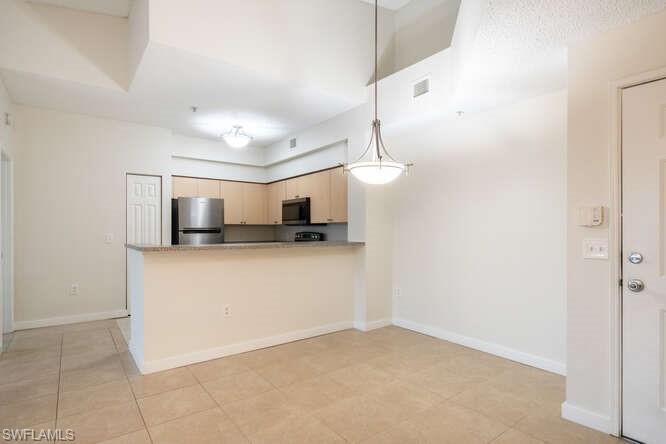 1220 Reserve Way, Unit 305 Naples, FL 34105 - Photo 8 of 20 a view of kitchen with microwave and refrigerator