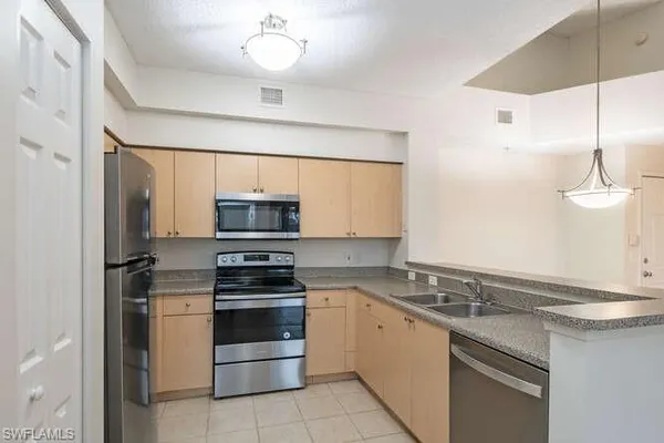 a kitchen with a stove a sink and a microwave