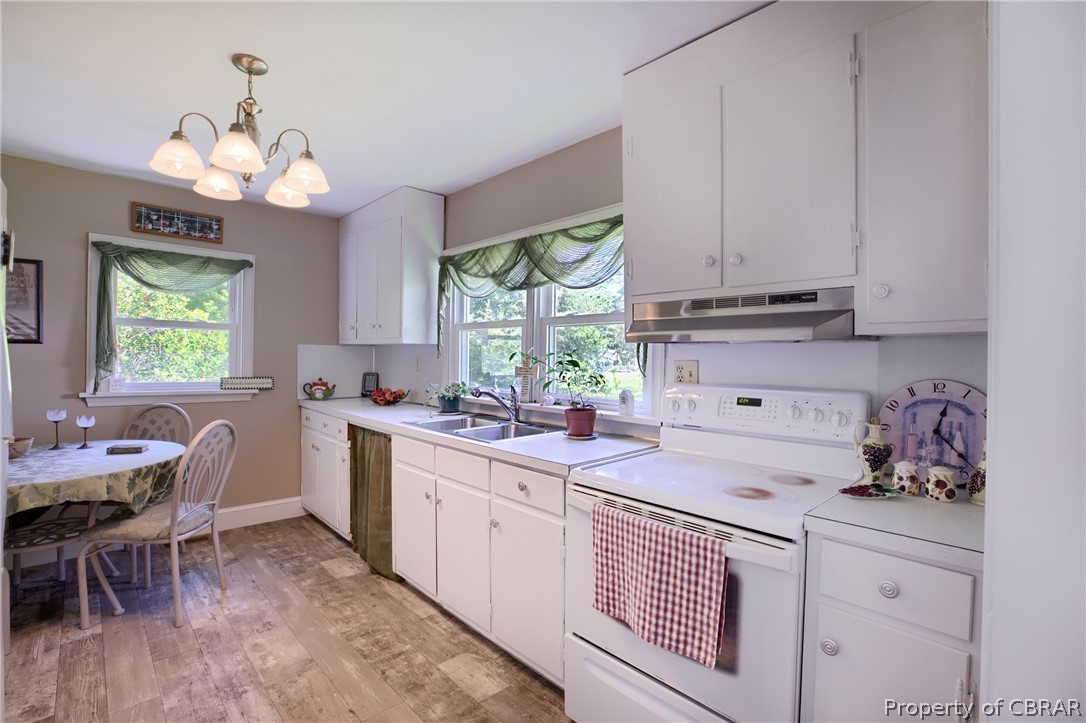 2442 Old Ferry Road Hudgins, VA 23076 - Photo 7 of 33 Kitchen with decorative light fixtures, white range with electric cooktop, a wealth of natural light, and light hardwood / wood-style floors