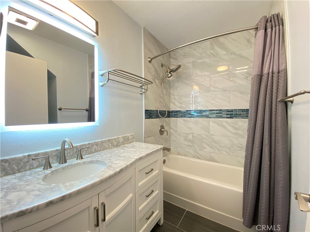 971 Saltcoats Drive Riverside, CA 92508 - Photo 18 of 50 a bathroom with a granite countertop sink mirror vanity and a bathtub