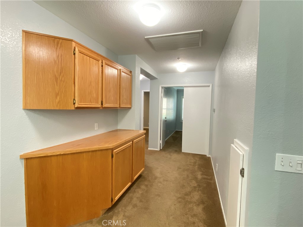 971 Saltcoats Drive Riverside, CA 92508 - Photo 21 of 50 a view of a hallway with stainless steel appliances granite countertop cabinets and a refrigerator