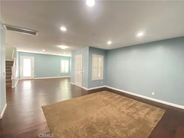 a view of an empty room with a kitchen and a fireplace