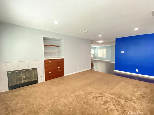 an empty room with a fireplace and windows