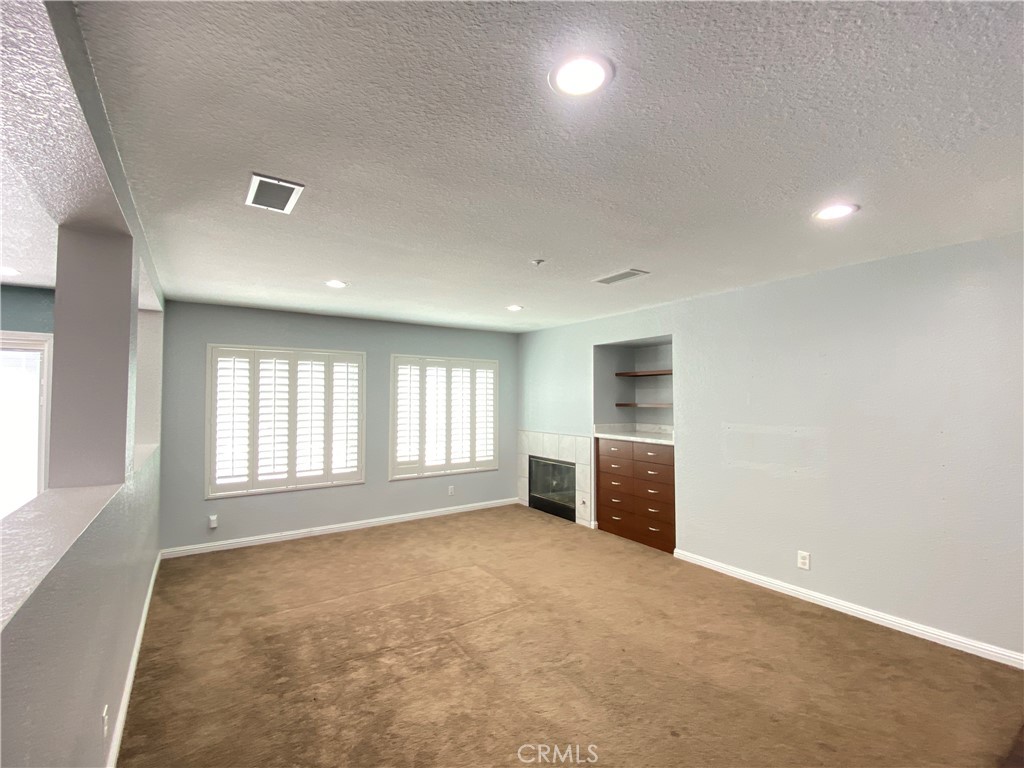 971 Saltcoats Drive Riverside, CA 92508 - Photo 8 of 50 an empty room with a fireplace and windows