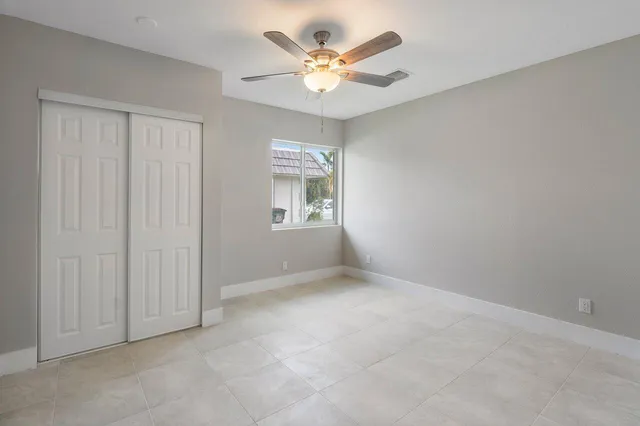 an empty room with window and a ceiling fan