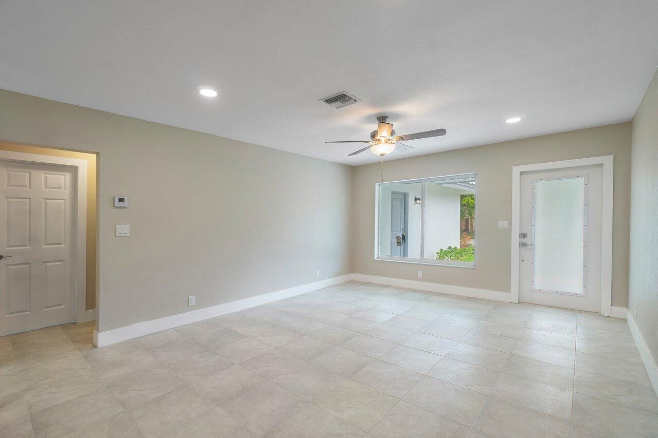 245 Southwest 6th Street Boca Raton, FL 33432 - Photo 4 of 40 a view of an empty room with chandelier fan and fire place