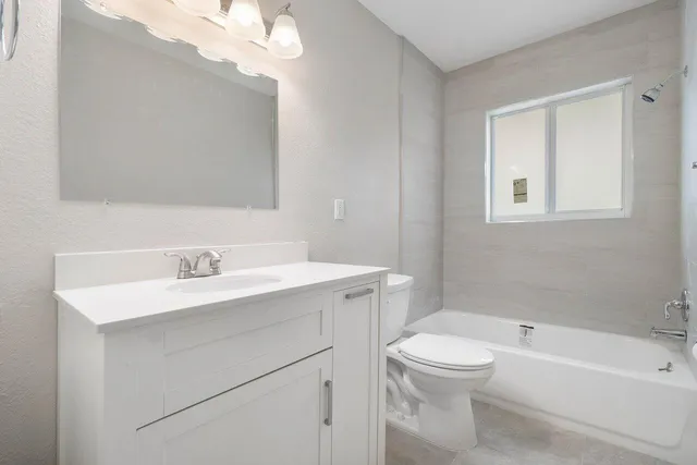 a bathroom with a toilet a sink a mirror and a bathtub