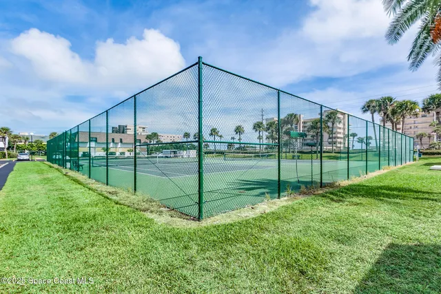 a view of a swimming pool with a chairs and floor to ceiling window