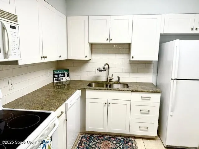 a kitchen with stainless steel appliances granite countertop a sink stove refrigerator and cabinets