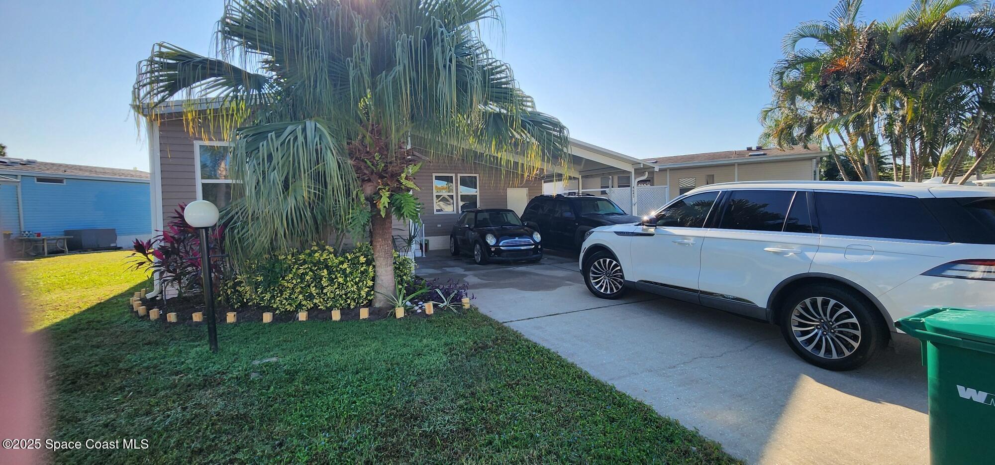 a view of a house with a garden and parking space