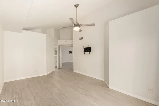 a view of a kitchen with wooden floor a ceiling fan and refrigerator