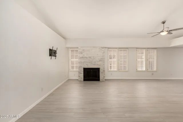 wooden floor fireplace and windows in an empty room