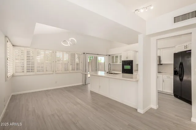 a view of kitchen with stainless steel appliances cabinets and wooden floor