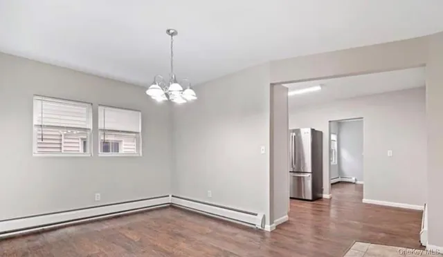 a view of a room with a chandelier fan and windows