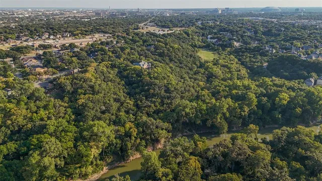 an aerial view of residential houses with outdoor space and trees